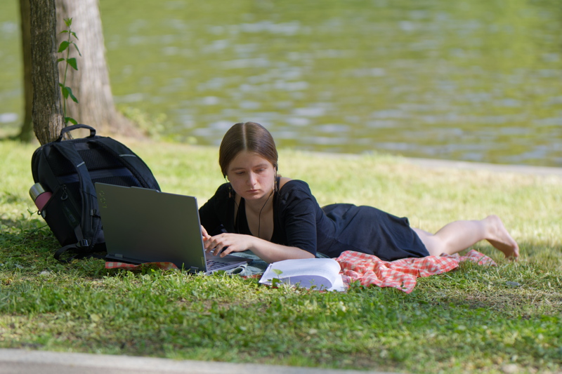 Girl with laptop on lakeshore
